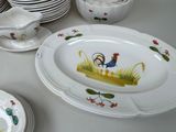 many plates and bowls on the table with roosters painted on them