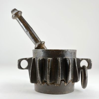 une vieille casserole en fonte munie d'une poignée en métal et d'une poignée en bois