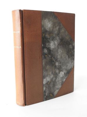 an old book sitting on top of a white table next to a white wall