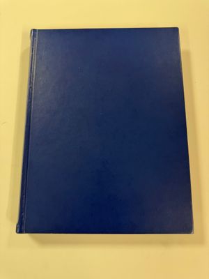 a blue book sitting on top of a table next to a white wall