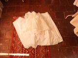 a white dress laying on a red rug on the floor