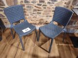 two blue chairs sitting next to each other on a wooden floor