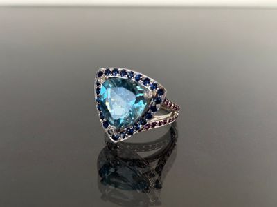 an image of a ring with a blue topazr and blue sapphires