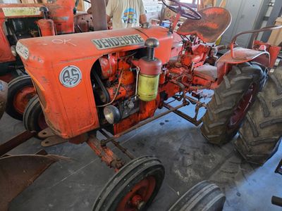 a red tractor that is parked in a garage