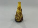 vase en verre jaune avec un socle marron sur un fond blanc