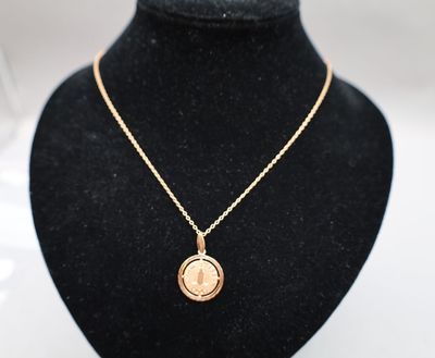 un collier en or orné d'une pièce de monnaie, sur un mannequin noir