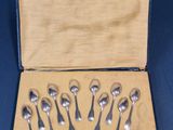 six cuillères en argent dans une boîte contenant une cuillère