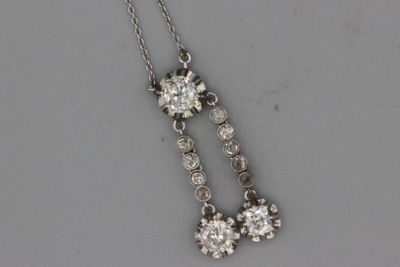 une photo représentant une paire de pendentifs en diamant suspendus à une chaîne