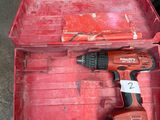 a red tool box with a drill in it on the ground