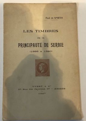 an old book sitting on a table with a shadow of a person