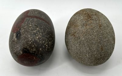 two rocks sitting next to each other on a white surface