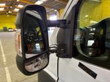 a side view mirror of a white truck in a garage