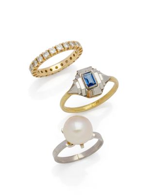 three different rings and a pearl ring on a white background