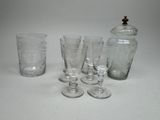 four glasses and a decanter sitting on a table