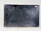a piece of black metal on a white surface