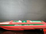 a red and green speed boat on a black surface
