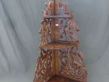 une étagère en bois ornée de sculptures sur fond gris