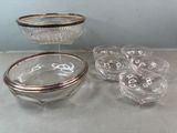 un saladier en verre et six verres posés sur une table