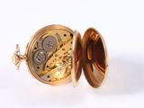 a gold pocket watch inside of it on a white surface