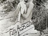 photographie en noir et blanc d'une femme assise par terre, tenant une serviette