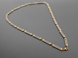 un collier en or et en argent sur un fond noir