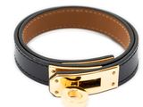 a close up of a black leather bracelet with a gold clasp