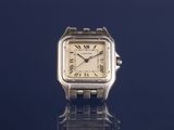 an image of a silver watch on a blue surface