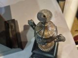 a small metal object sitting on a table next to a mirror