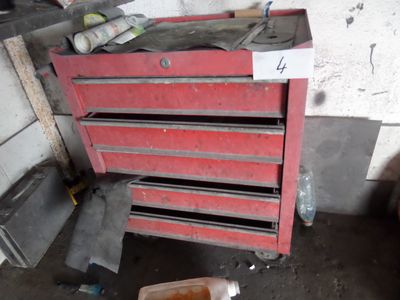 une boîte à outils rouge sur laquelle sont posés de nombreux outils