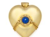 une image représentant un cadenas doré en forme de cœur, orné d'une pierre bleue en son centre