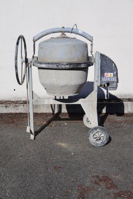 a cement mixer sitting on the side of the road