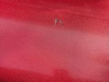 someone is holding a red suitcase that is sitting on the floor