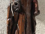 wooden statue of a man holding a dog on a marble base