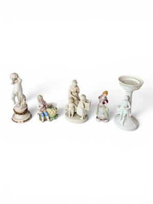 Plusieurs figurines de tailles et de formes variées sont disposées sur une surface blanche