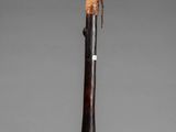 a close up of a wooden stick with a bird on it