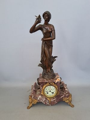 a statue of a woman holding a bird and a clock