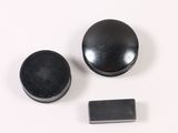 two black knobs on a white surface next to each other