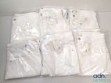 Plusieurs sacs contenant des chemises blanches sont posés sur une table