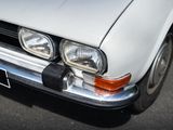 a white car parked on the street with its hood up