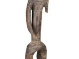 une vieille statue en bois représentant un homme coiffé d'un casque