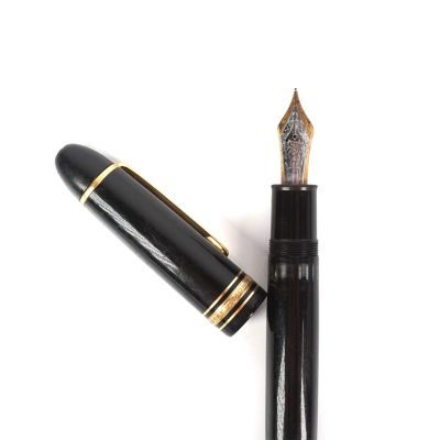 un gros plan d'un stylo plume doté d'une plume noire et de finitions dorées