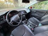 l'intérieur d'une voiture rouge équipée de sièges en cuir noir et de commandes au volant