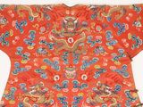 an orange chinese robe with a dragon design on it