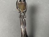 a silver spoon with a mirror on it sitting on a table