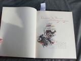 a person holding a book open on a bed