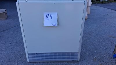 un réfrigérateur blanc, sur lequel est collé un autocollant, posé sur le trottoir