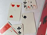 several playing cards are laid out on a table next to a laptop