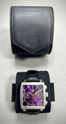 purple and black watch and case on a white surface
