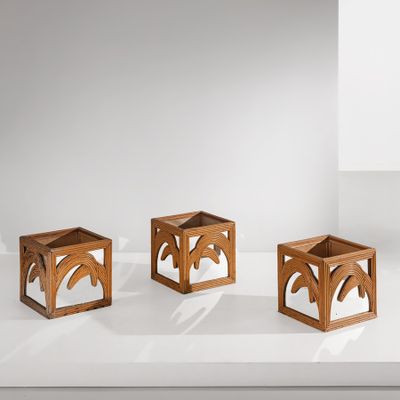 trois cubes en bois posés sur une surface blanche, avec des ombres qui se dessinent dessus