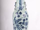 un vase bleu et blanc sur lequel est posée une lampe